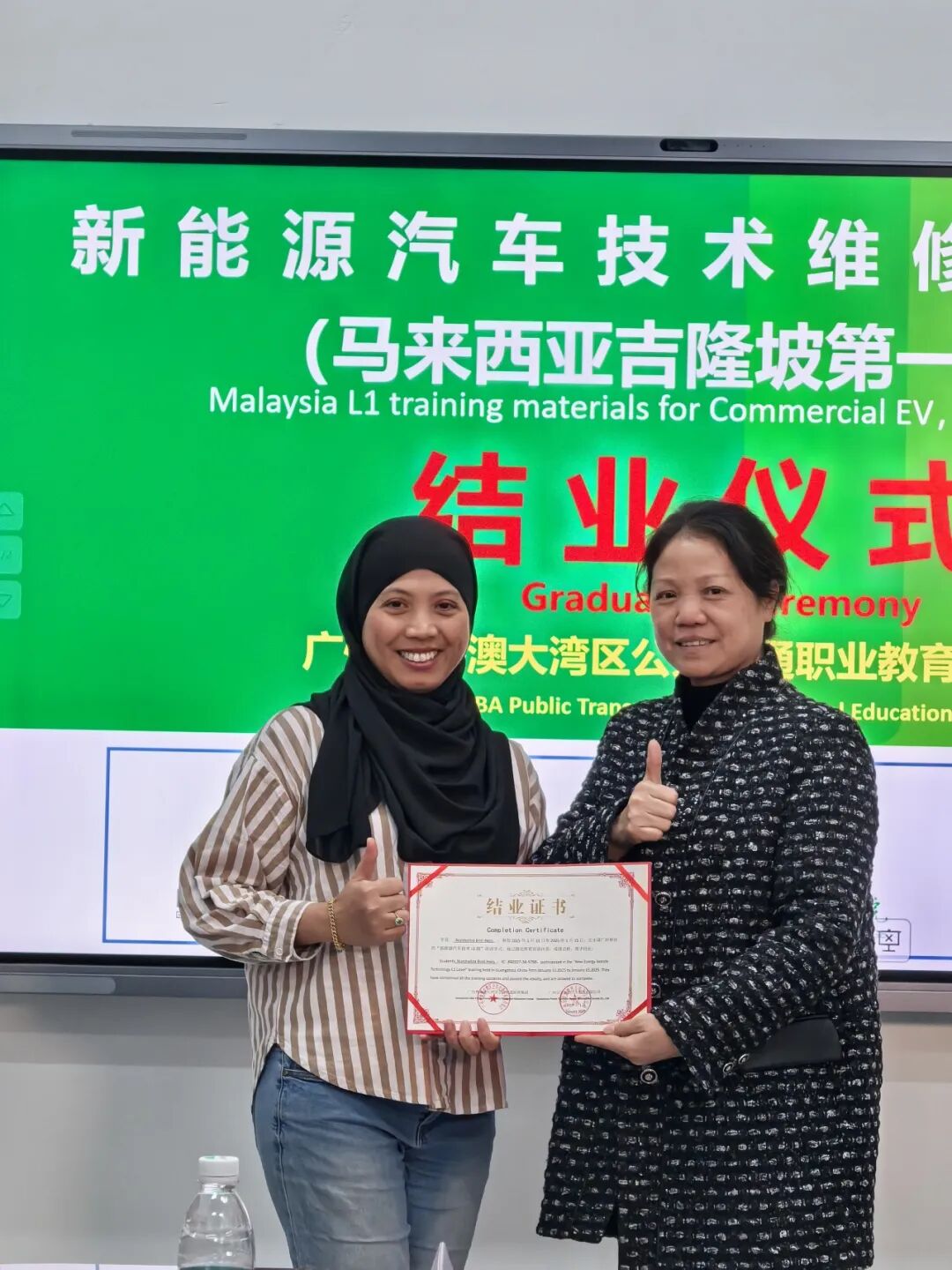 International female technician receiving Chinese EV repair completion certificate