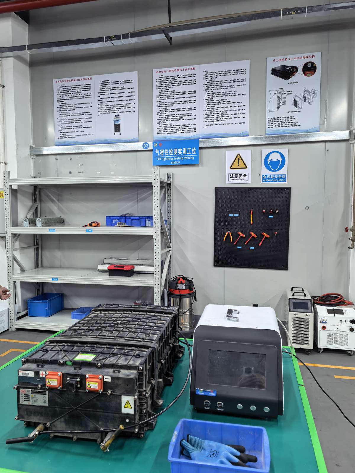 Battery pack airtightness testing station with insulated tools at NEV Fix training facility