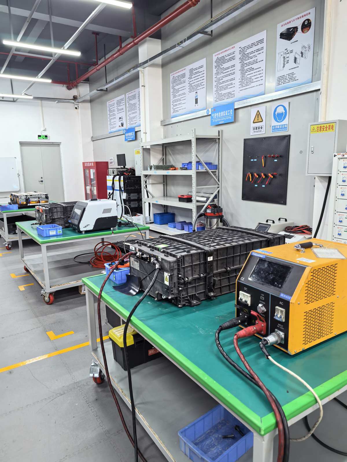 Multi-station battery repair training facility at NEV Fix Guangzhou — full workshop setup capability