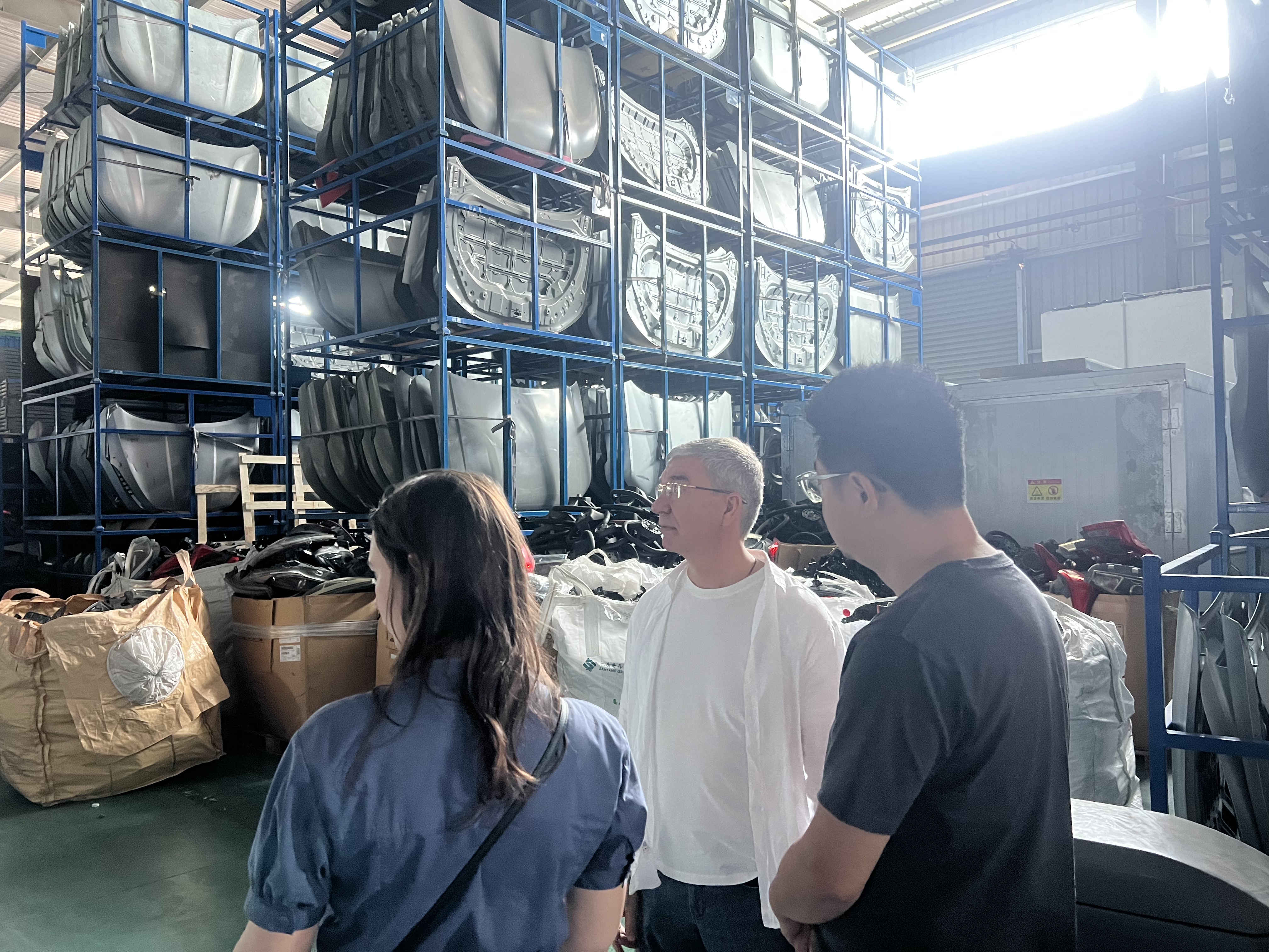 Russian repair shop client visiting NEV Fix warehouse in Guangzhou discussing Chery Tiggo 7 Pro parts